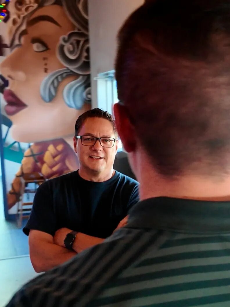 Two dads talking near the mural at False Idol Brewing