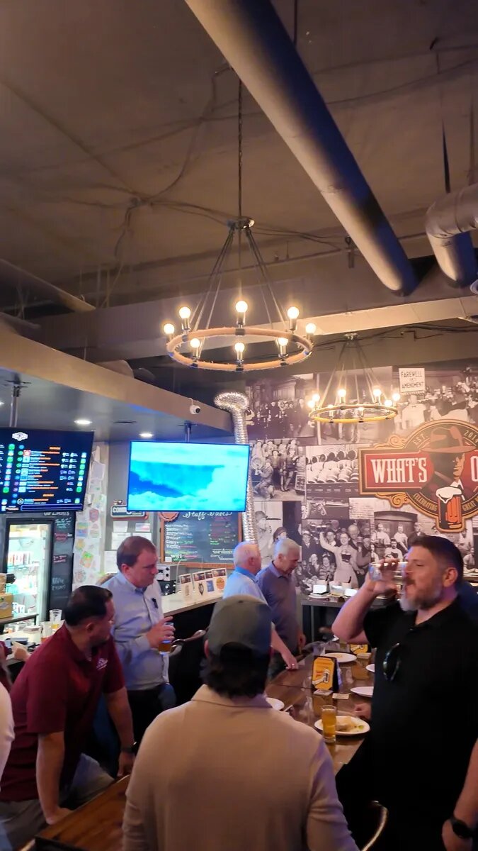 Dads gathering around a high table at What's On Tap