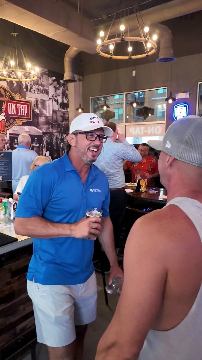 Two dads smiling during a conversation at What's On Tap